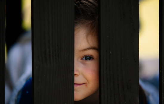 deprsja u dzieci i młodzieży, dziewczynka uśmiechająca się podczas zabawy na podwórku szkolnym