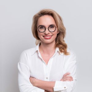 uśmiechnięta kobieta w białej koszuli
